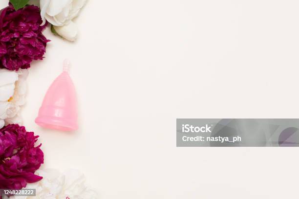 Pink Menstrual Cup For Women With Flowers On Light Background Ecological Alternative To Gaskets And Tampons Stock Photo - Download Image Now
