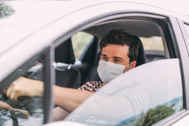 istock Man Wearing a Sterile Mask Driving a Car 1248232972