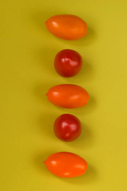 istock Orange and red tomatoes on olive color background. Vertical position. 1248234820