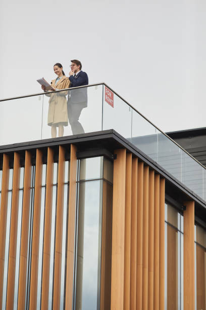 istock Two Real Estate Agents Standing on Roof 1248235397