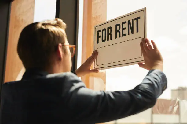 Photo of Real Estate Agent hanging For Rent Sign