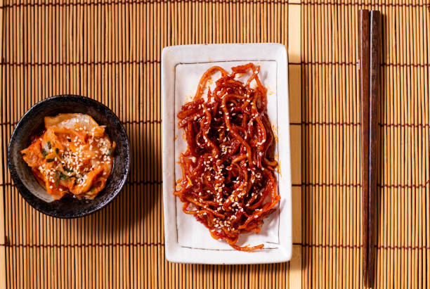 istock Seasoned dried shredded squid (ojingeochae muchim) with kimchi on wood table 1248236923