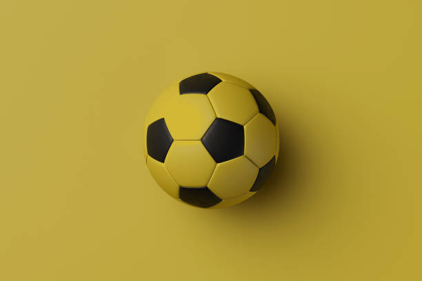 istock black yellow classic soccer ball isolated on yellow background, 3d rendering 1248239745