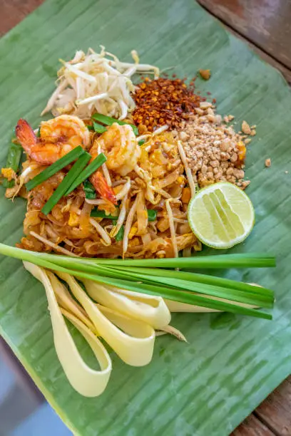 Photo of PadThai, The Traditional of Thailand Fried noodle with prawns on the banana leaf ready to serve for lunch.