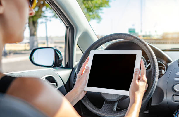 istock Woman holding tablet computer sitting in the car. 1248242229