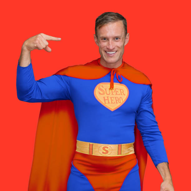 Waist up of hero standing in front of colored background wearing cape - garment who is conquering adversity who is pointing