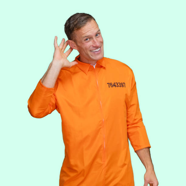 istock Criminal standing in front of colored background wearing jumpsuit 1248243360