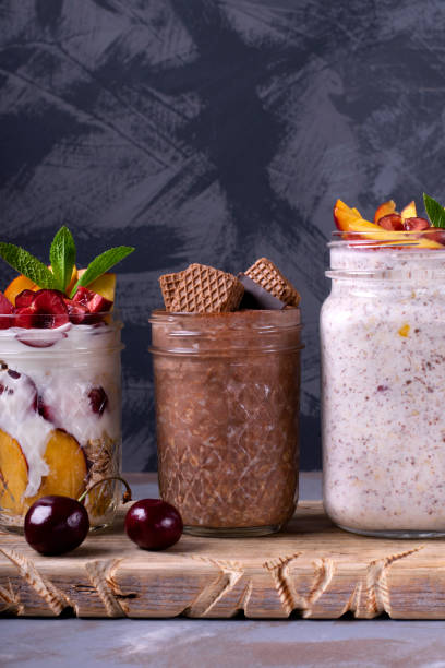 overnight oats assortment in glass jars - three different refrigerators imagens e fotografias de stock