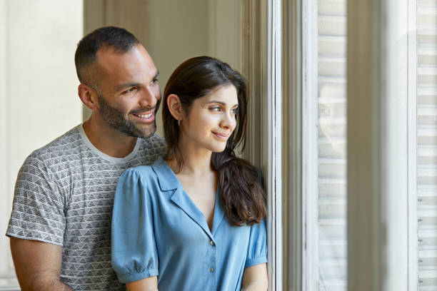 istock Smiling mid adult couple looking through window 1248254338