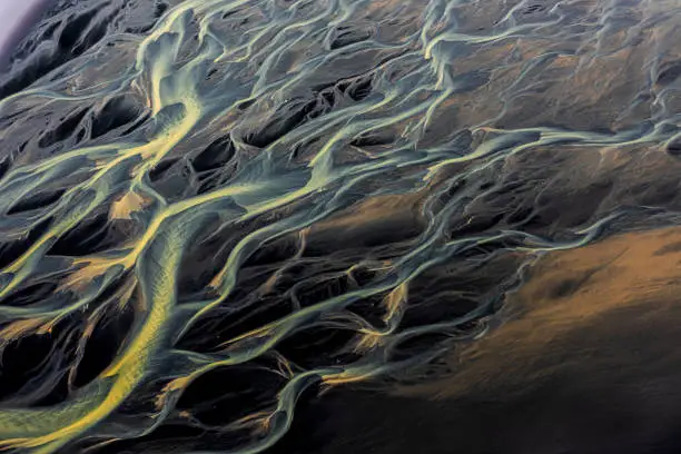 Iceland glacial river flowing into the sea, shot from a helicopter.
