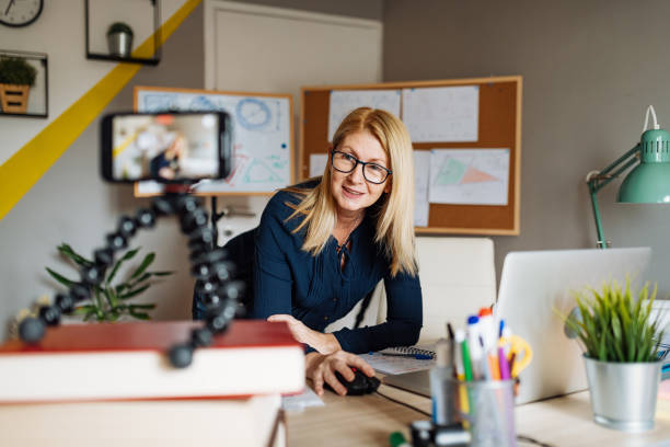 istock E-learning - professor at home, looking and talking direct to camera 1248255444