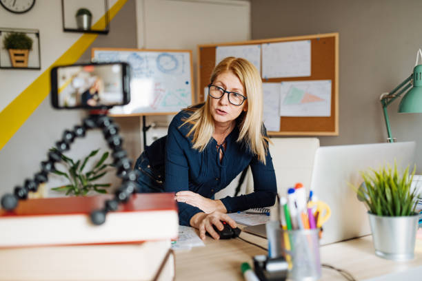 istock E-learning - professor at home, looking and talking direct to camera 1248255544