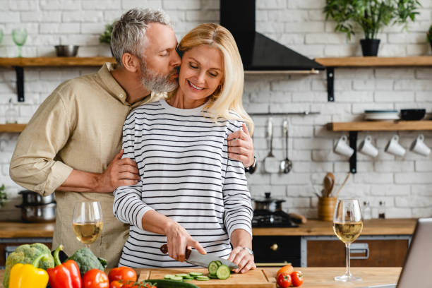 istock Happy mature couple kissing and hugging in kitchen while cooking 1248256275