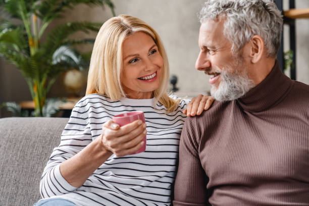 istock Smiling middle aged mature couple laughing and drinking coffee, having fun at home 1248256606