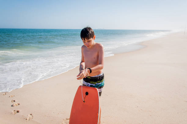 istock Boy preparing board to enter the sea 1248259085