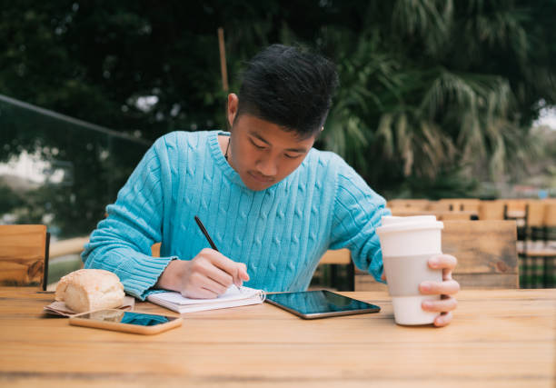 istock Asian man studying in coffee shop. 1248259559