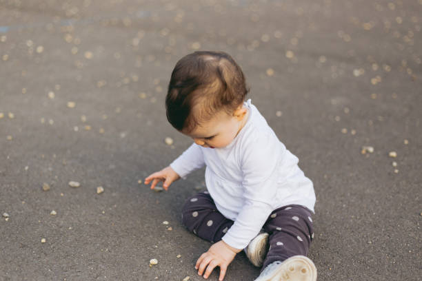 istock Baby sitting on ground 1248260865