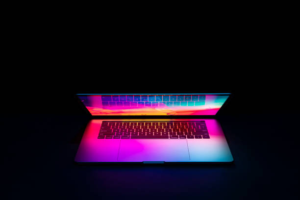 isolierte high-tech-open-laptop mit abstrakten lebendigen farbbildschirm auf einem dunklen hintergrund. - color display stock-fotos und bilder