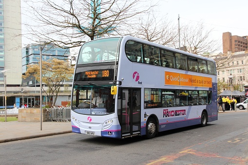 People ride FirstGroup city bus in Manchester, UK. FirstGroup employs 124,000 people.