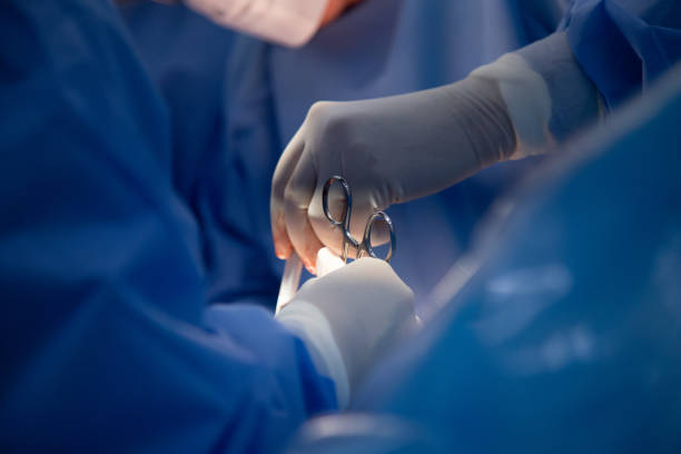 equipo médico de cirujanos en el hospital haciendo cesárea - operating fotografías e imágenes de stock