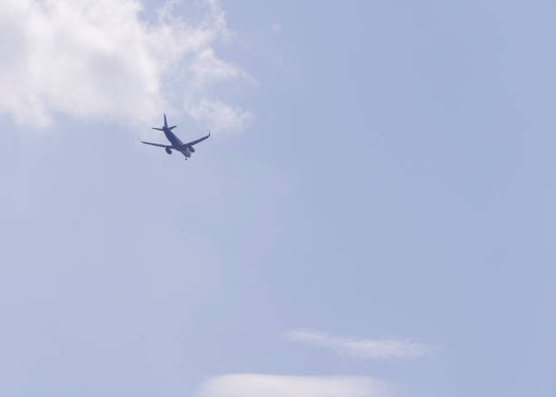 plane flying away into the distance against a blue sky
