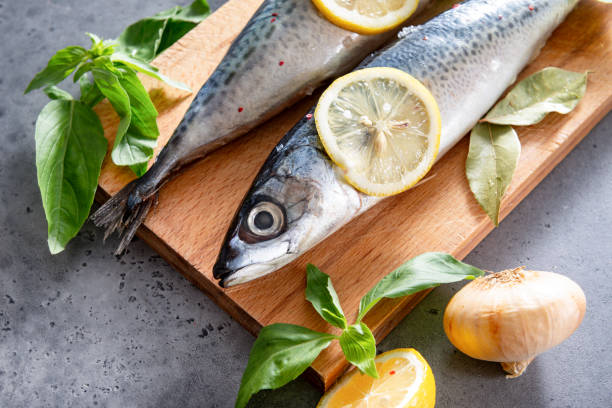 istock 2 raw mackerel fish with spices and lemon slices on a cutting Board, Basil, onion on a gray background 1248268029