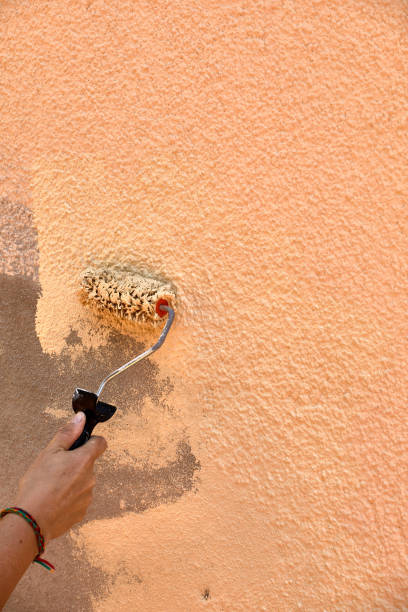 istock Hand painting wall with cream roller vertical 1248274276