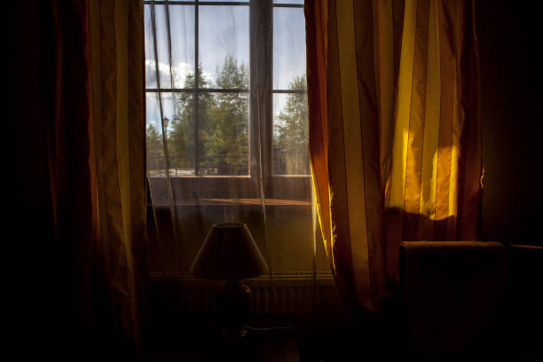 istock A dark room with a window and yellow curtains 1248278180