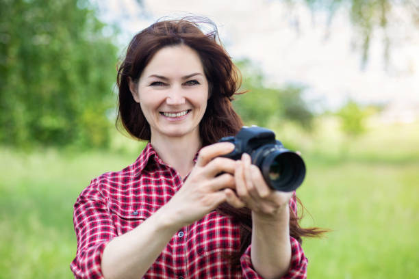 istock Woman photographer holding a camera in her hands . 1248283310