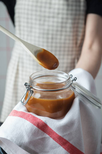 istock Woman in a checkered apron holding fresh hot caramel 1248285256