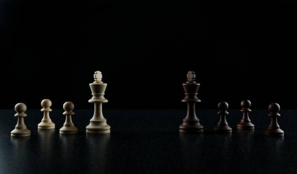 istock chess kings face to face on black background. 1248286758