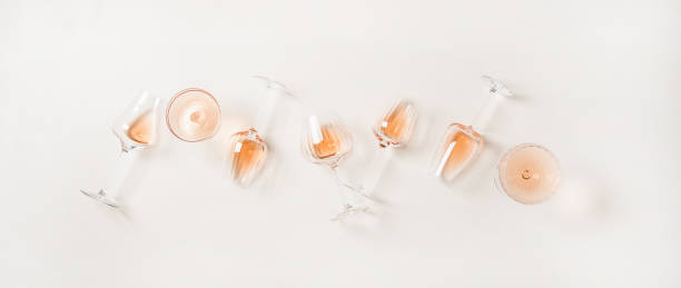 flat-lay of rose wine in glasses over plain white background - white wine wine white glass imagens e fotografias de stock