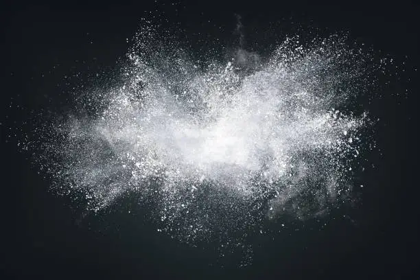 Abstract design of white powder or dust particles cloud explosion and splash with smoke flying over black background