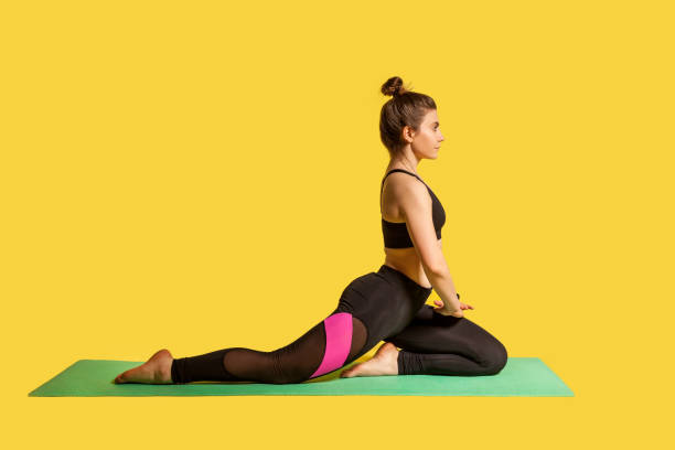 istock Serious motivated sportswoman practicing yoga on mat, doing one legged king pigeon pose, warming up stretching muscles 1248292464
