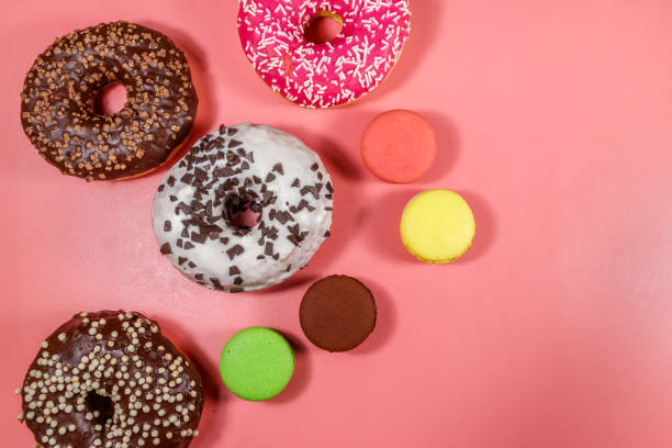 istock Tasty donuts and macaroons on pink background. Top view 1248293879