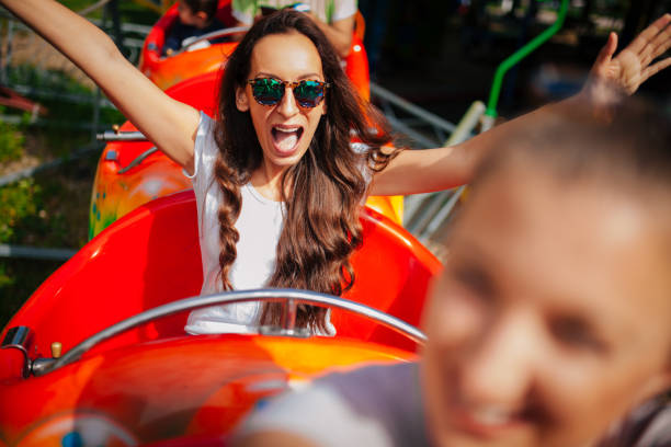 Conceptual image of people riding in rollercoaster and city skyline,  blurred motion