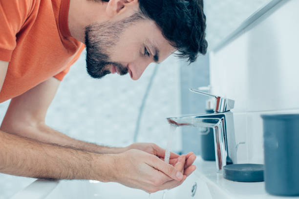 istock Smiling man watching water running into his hands 1248298545