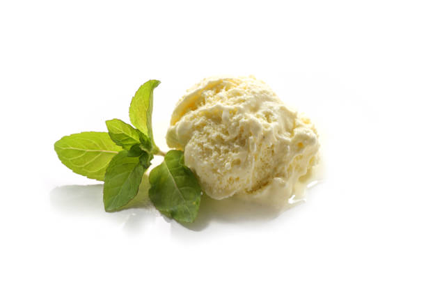 istock Vanilla ice cream scoop and a peppermint leaf isolated on a white background 1248300153