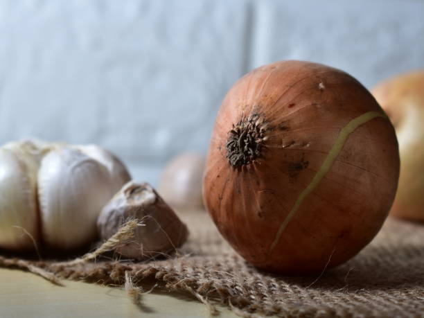 istock Organic onions and garlics on a brown jute cloth 1248300426