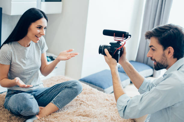 istock Man with camera recording smiling young woman 1248300866