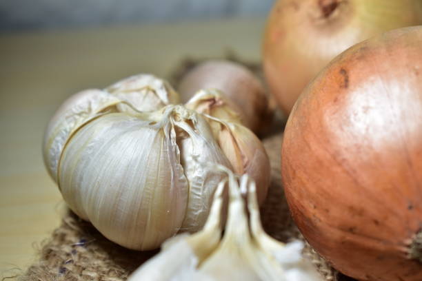 istock Organic onions and garlics on a brown jute cloth 1248302267