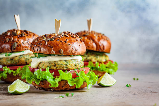 Vegan falafel burger with vegetables and sauce, dark background, copy space. Healthy  plant based food concept. Vegan falafel burger with vegetables and sauce, dark background. Healthy food concept. veganism photos stock pictures, royalty-free photos & images