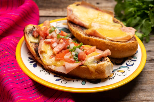 istock Mexican molletes with ham and cheese on wooden background 1248302556