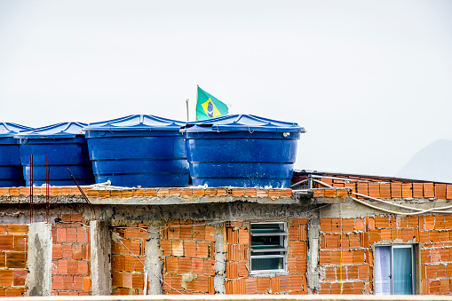 tanque de agua en la parte superior de una casa con la bandera de Brasil en la colina de cantagalo photo