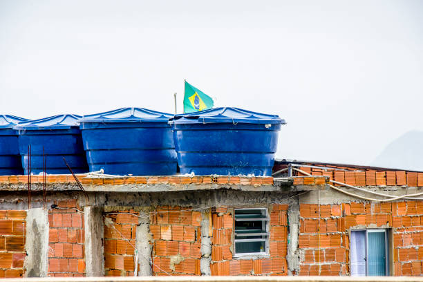 water tank on top of a house with the flag of brazil on the hill of cantagalo stock photo