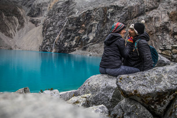 istock couple sitting near a turquoise lake 1248306821