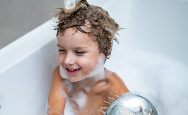istock Little boy is using shower in bathtub 1248310334