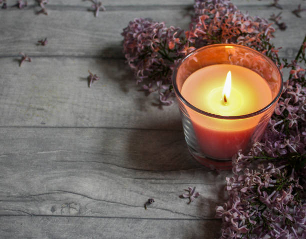 istock Pink candle and lilac flowers 1248313033