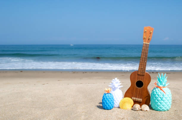istock Ukulele on the sand at a beach, with a blue ocean background. 1248318199