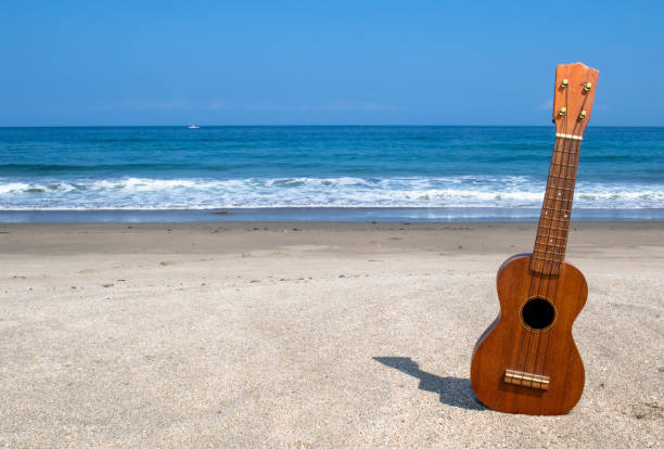 A Hawaiian musician plays the ukulele during a traditional performance, wearing a floral dress and lei that reflect the warmth and culture of the islands.